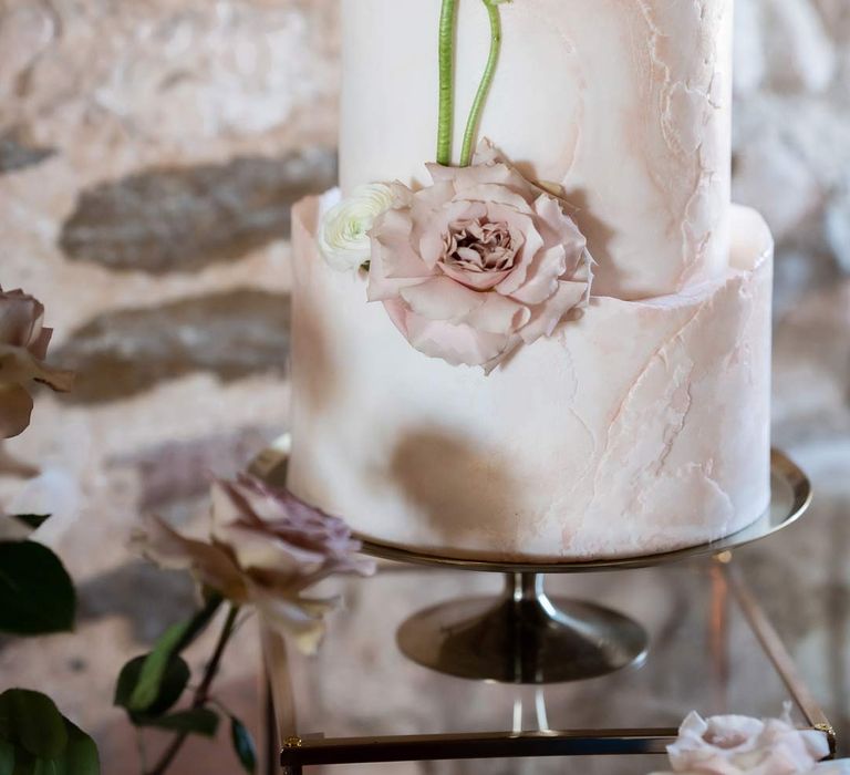 Close up of fairytale four tier wedding cake with garden rose wedding cake decorations 