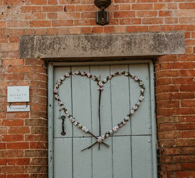 Baby blue barn door with heart shaped wedding wreath and autumnal boho dried flower bouquets at Bassmead Manor Barns