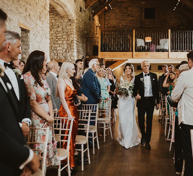 The bride and father of the bride walk up the aisle for a  rustic barn summer wedding at Priston Mill, Bath 