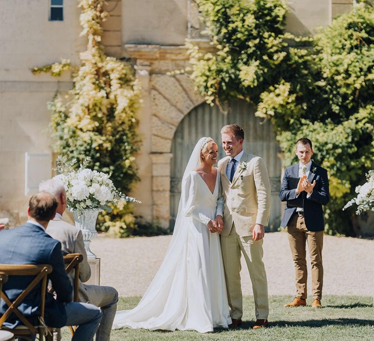 Bride in a floaty wedding dress and groom in a beige suit at Château de Malliac, French destination wedding 