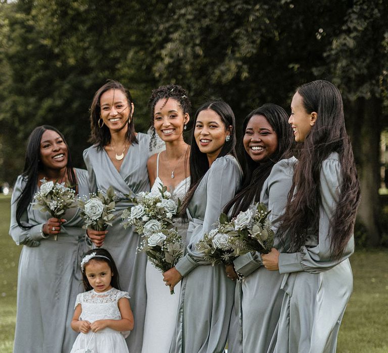 Bridesmaids in satin long sleeve wrap dresses with white rose bouquets 