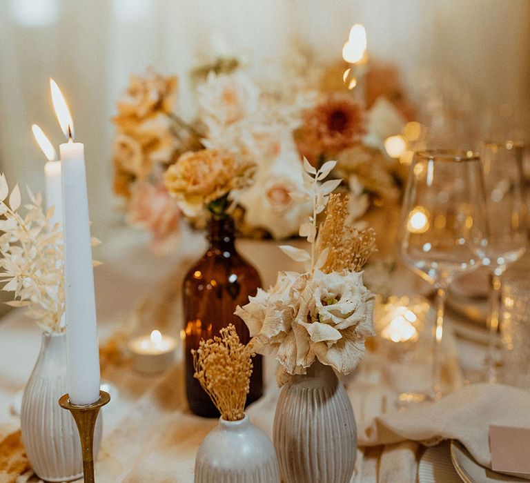 candles, dried and fresh flowers in vessels muted colour palette wedding table decor 