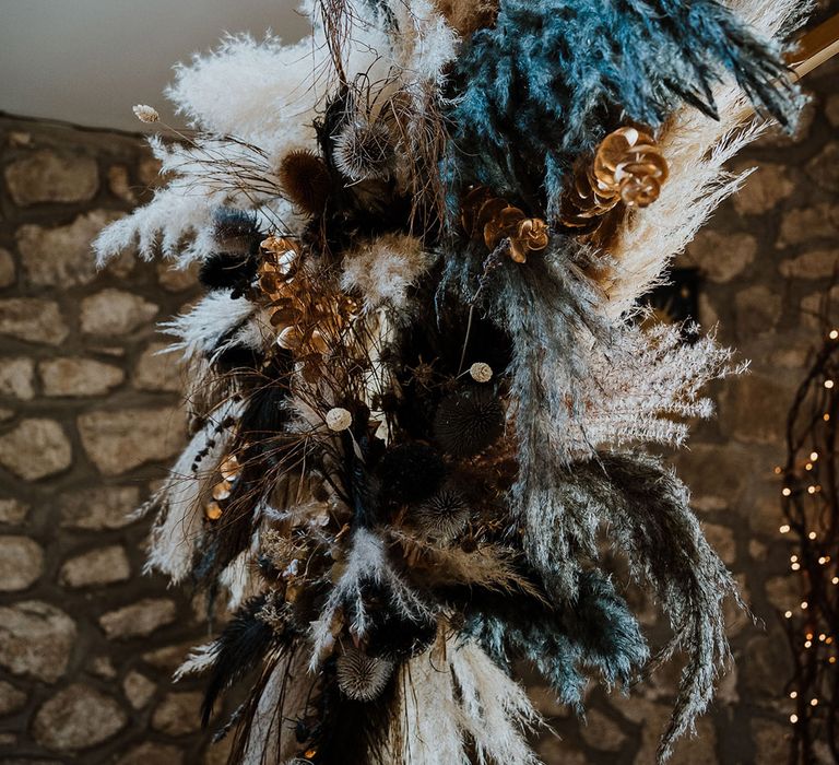 Blue and neutral wedding pampas grass decor on the moong gate at the altar 