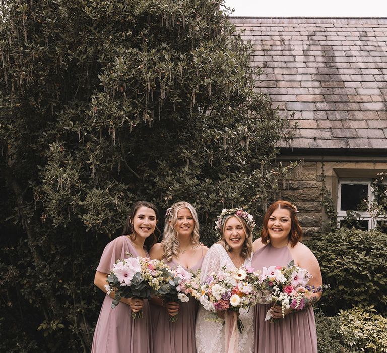 Bride posing with bridal party in pink bridesmaid dresses for Wyresdale Park wedding 