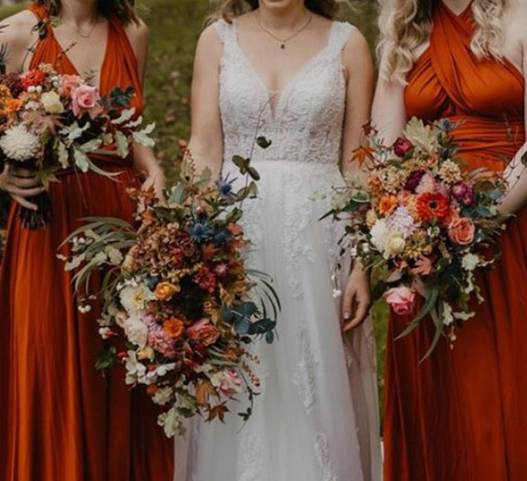 Bridesmaids holding textured cascading wedding bouquet for autumn wedding day with burnt orange bridesmaid dresses 