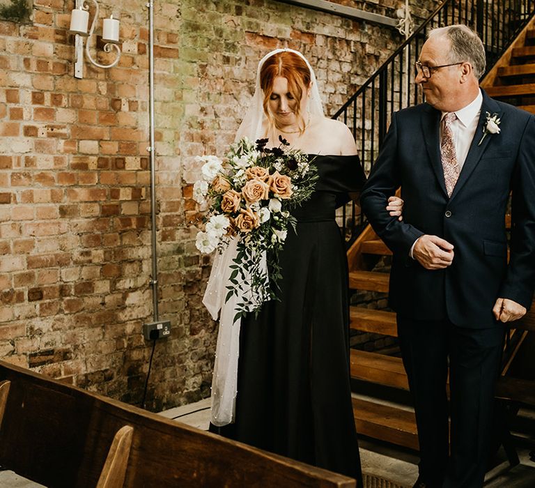 Bride wearing untraditional black wedding dress for rustic October autumnal wedding 