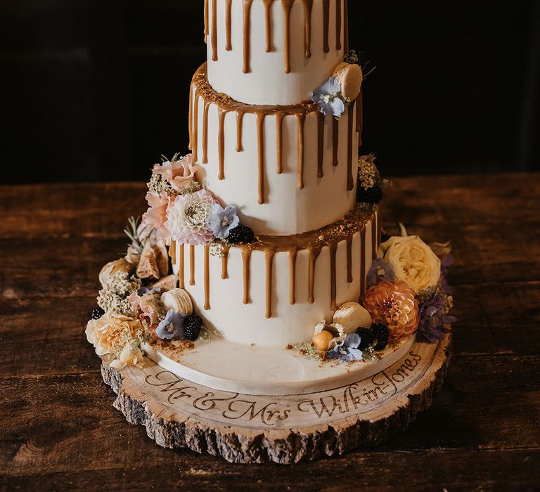 Three tier buttercream wedding cake with drip icing and pastel wedding flowers 