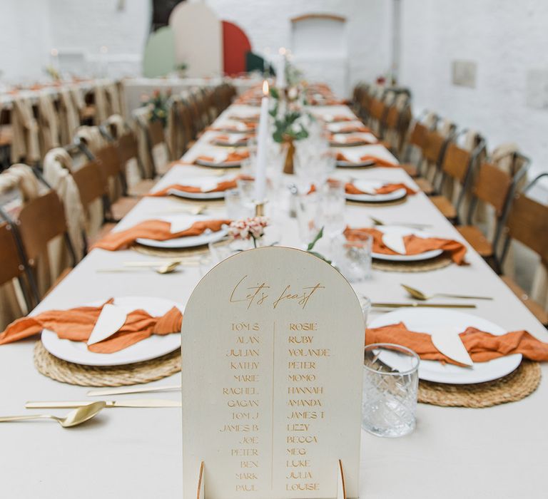 Wedding table plan sign on the ends of the table with burnt orange napkins for simple tablescape 