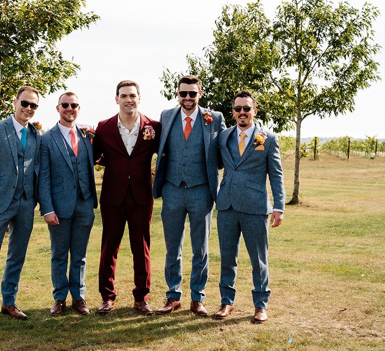 Groomsmen in blue wedding suits posing together for group photo 