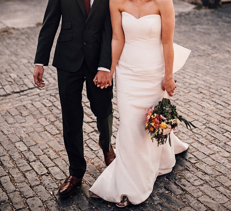 Bride in strapless wedding dress laughing with the groom for couple portrait 