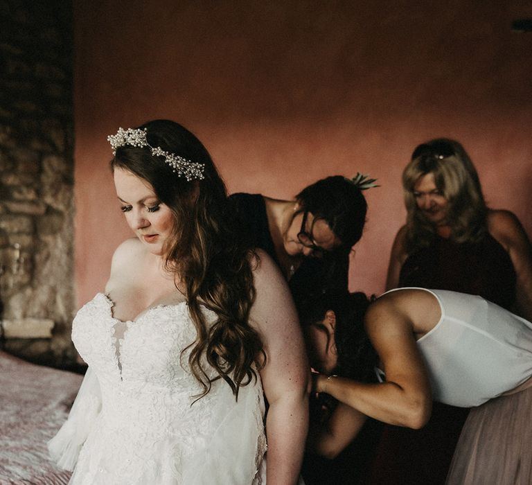 Bridesmaids helping Saskia get into her dress