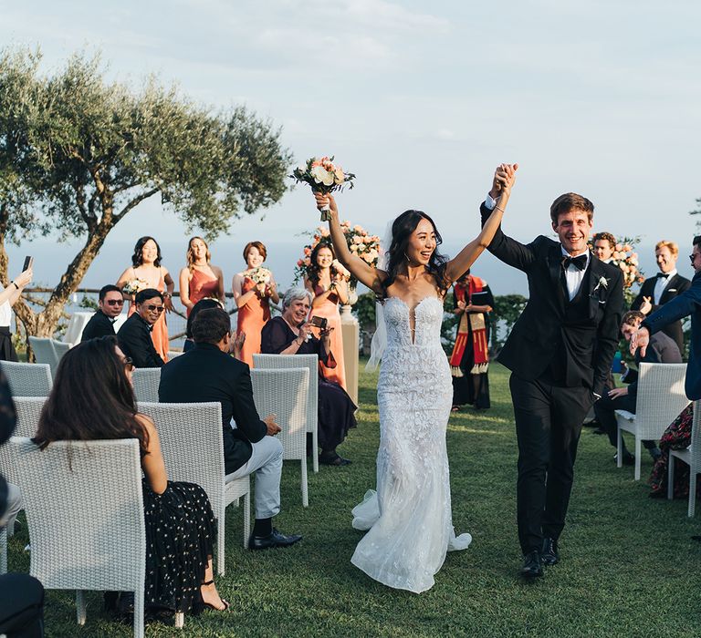 Bride and groom walking up the aisle as husband and wife at their Villa Cimbrone wedding in Italy 