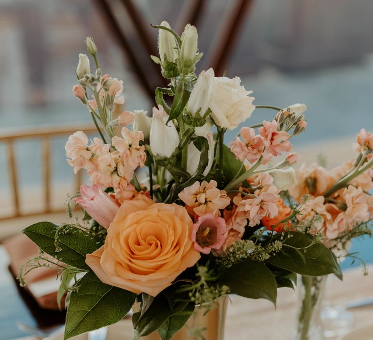 Wedding floral arrangement with orange, coral and blush pink and peach flower stems 