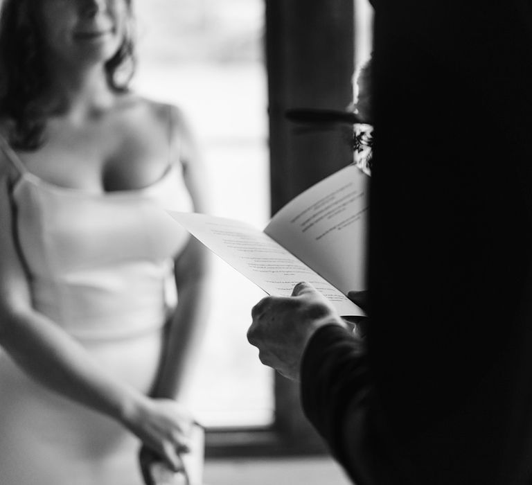 The groom reading his vows from a vow book by Bride Disrupted