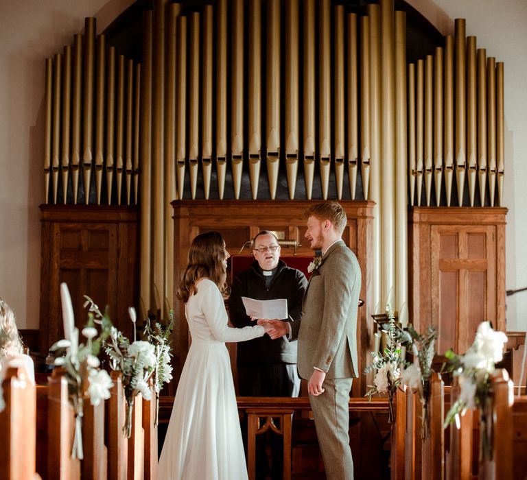 The bride and groom exchanging vows at their methodist wedding ceremony