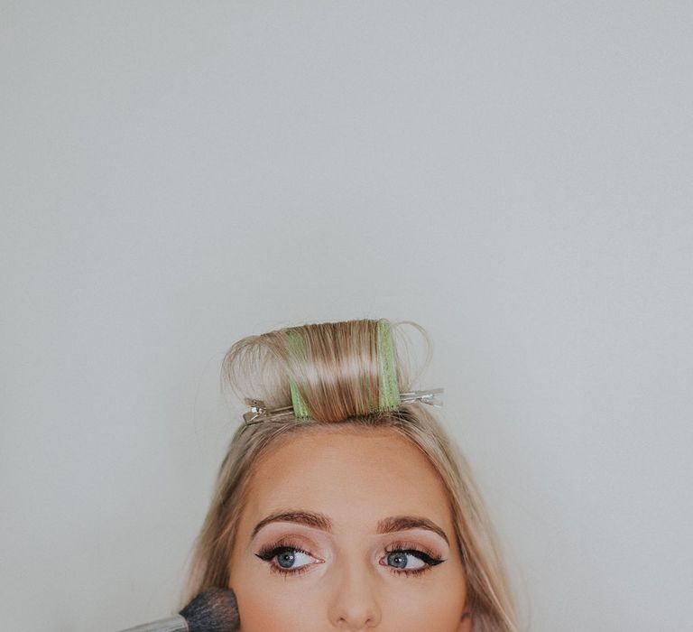 Bride with roller in her fringe looking to the side at Caswell House wedding