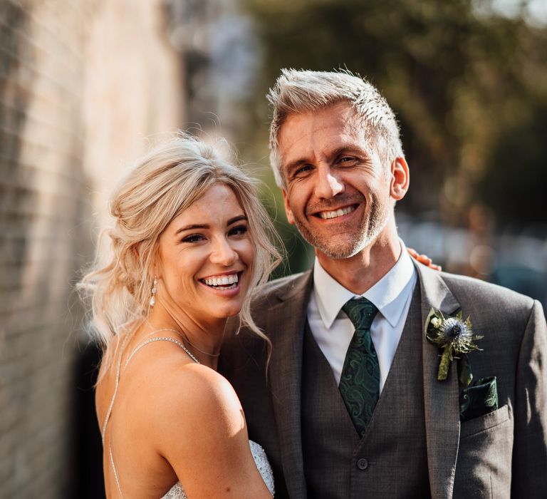 Bride & groom embrace in the sunshine after wedding ceremony