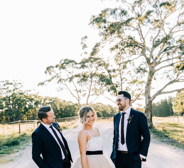 Bride in tulle skirt wedding dress with groomsmen