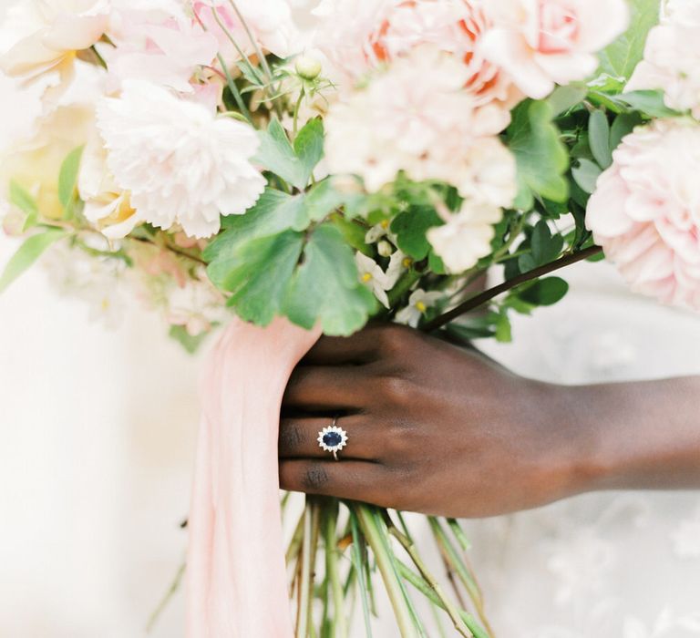 Bouquet of pink roses and carnations with a sapphire wedding ring