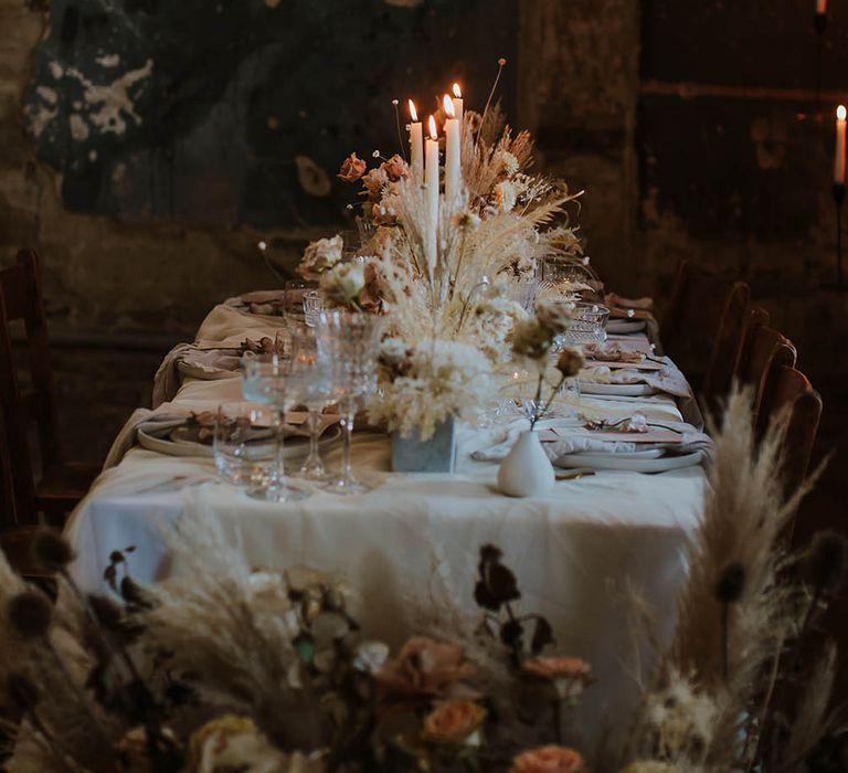 Neural dried flower centrepiece decor and white taper candles 