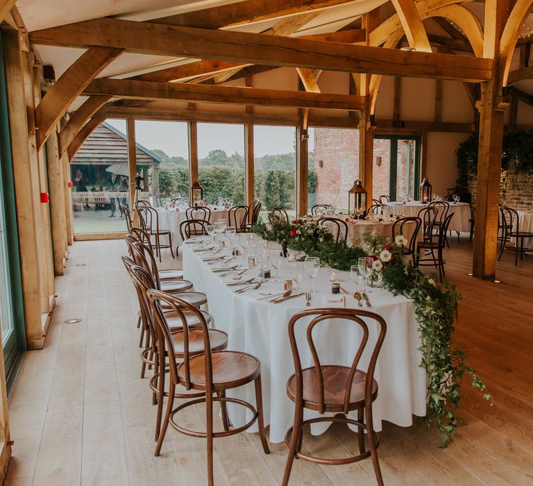 Wedding reception at Hazel Gap Barn with top table floral arrangement table runner 