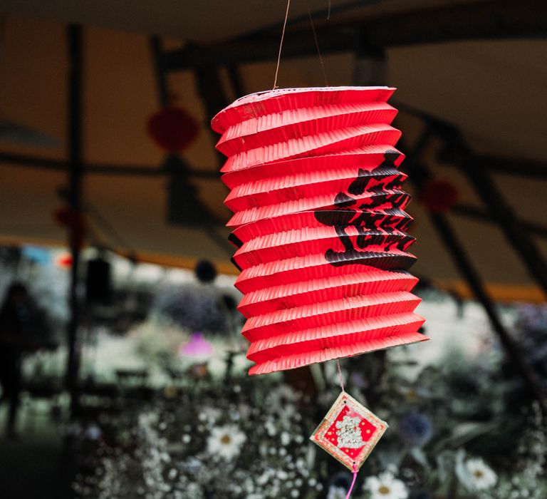 Chinese lantern in bright red hangs from tipi 