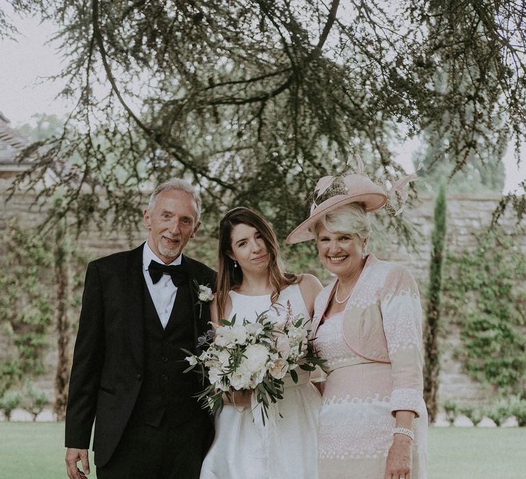 Bride stands with her mother and father of the day of her wedding whilst wearing Jesus Peiro dress