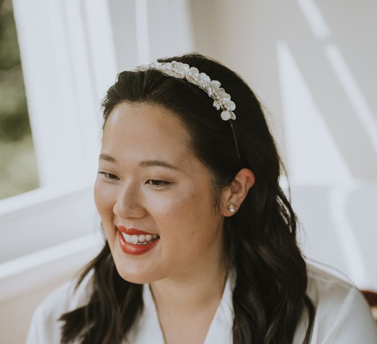 South Asian bride wearing a mother of pearl headband with red lipstick and highlighter subtle wedding makeup 