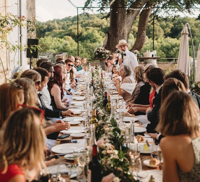 Outdoor wedding reception at Chateau Lagorce with banquet table and festoon lights 