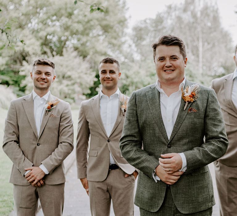 Groom and groomsmen in stone suits and a blue blazer 