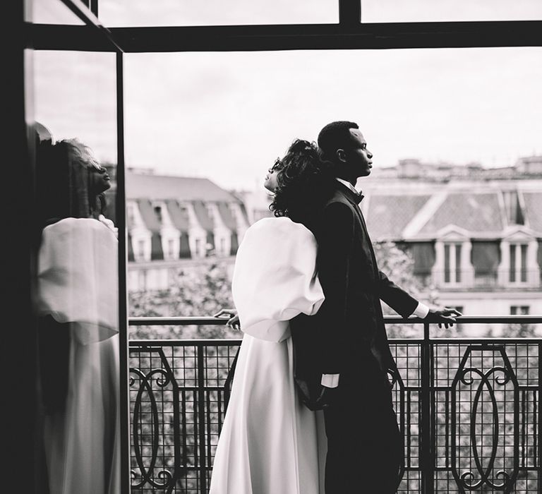 Stylish Paris elopement wedding with bride and groom standing on a balcony at The Kimpton Saint Honoré