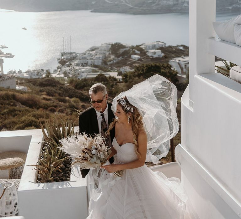 Bride holds dry floral bouquet with pampas grass outdoors in Greece for elopement wedding