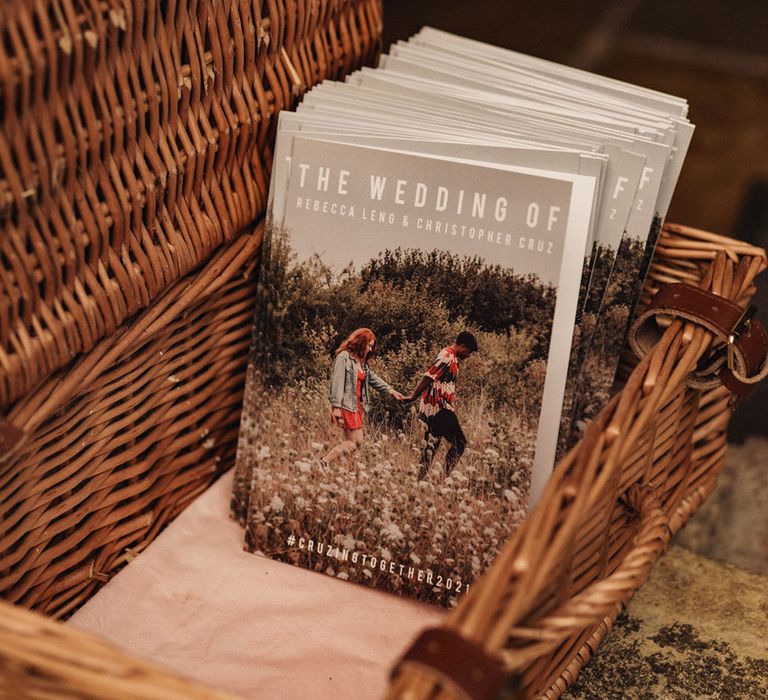 Wicker basket filled with personalised Order Of Service books for DIY wedding