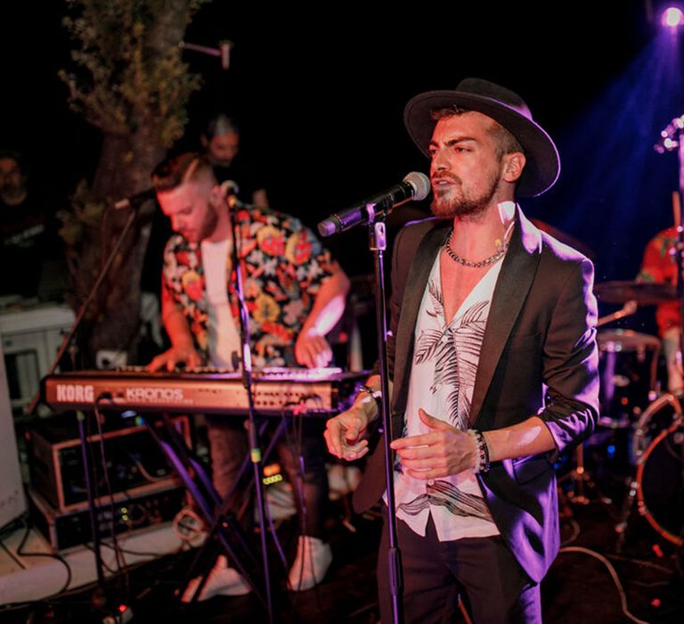 Band plays live during wedding reception outdoors for beach bar wedding in Greece 