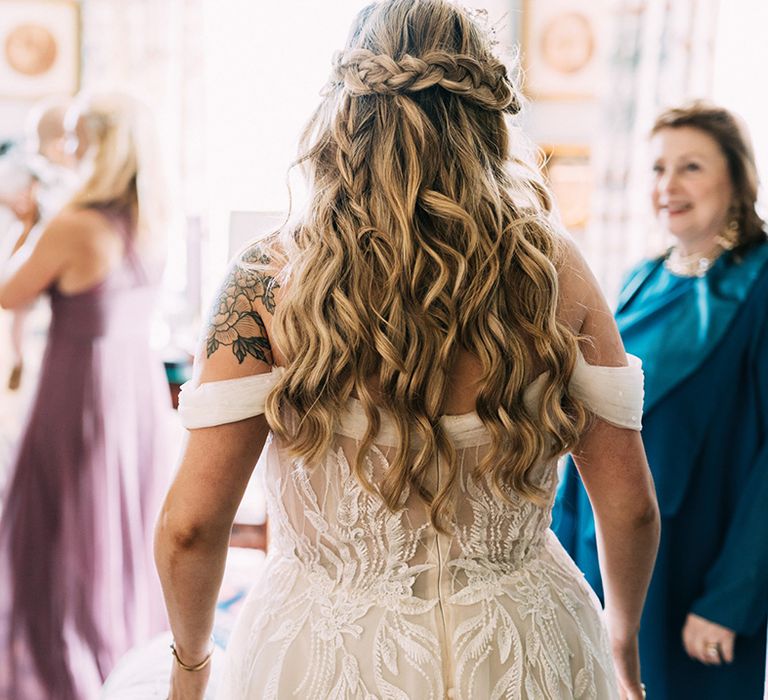 Bride with half-up half-down hair style with braid and sheer panel back detail wedding dress