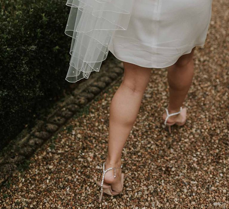 Vanessa Cocchiaro short wedding dress with long, white veil and Jimmy Choo heels