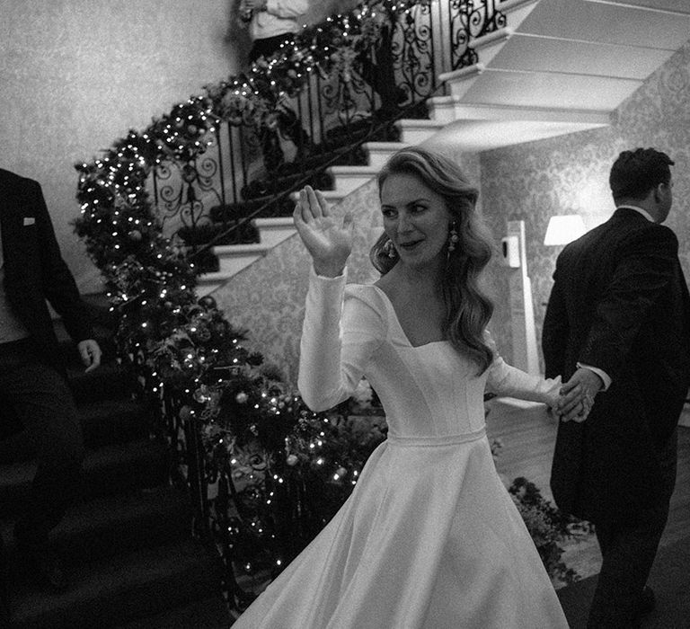 Bride in white long-sleeved wedding dress with square neck and full skirt 