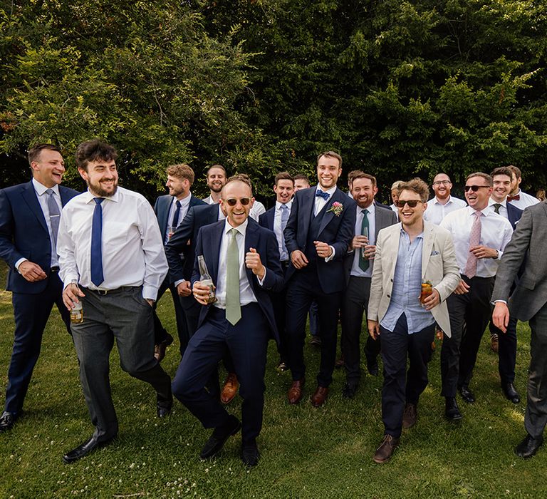 Groom in three piece blue suit with blue bow tie with all the men as part of the wedding party 