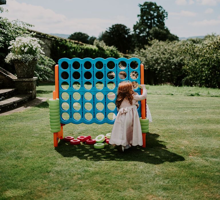 Little girl plays oversized garden games outdoors at Cowdray House 