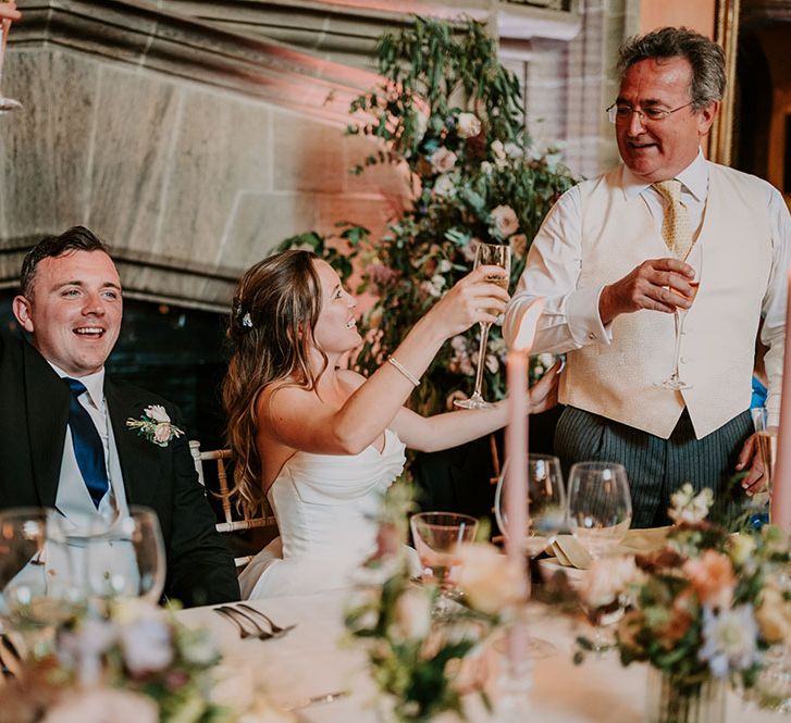 Bride & groom cheers during wedding speeches at Cowdray House