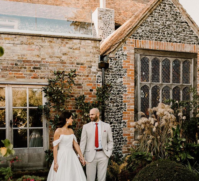 Bride and groom look into each other's eyes as they stand outside the Chapel House Estate wedding venue 