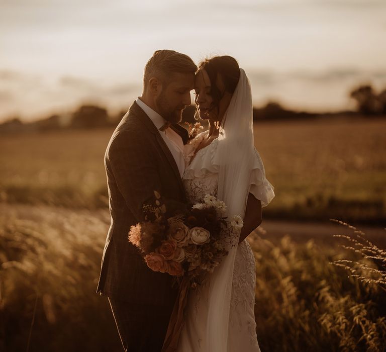 Bride and groom share an intimate embrace as the sun sets 