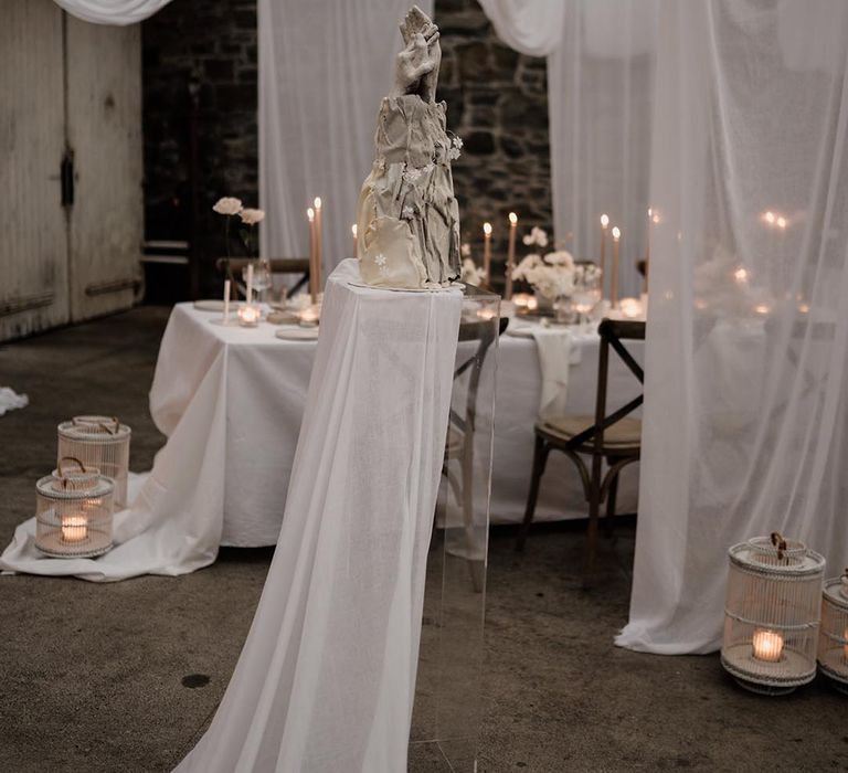 Wedding ceiling drapes decoration with fairy lights, artsy decor wedding cake with two hands and painted flowers 