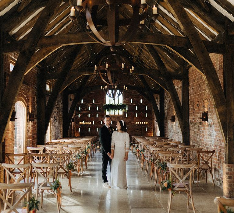 The bride and groom stand inside Grangefields wedding venue for their rustic barn wedding 