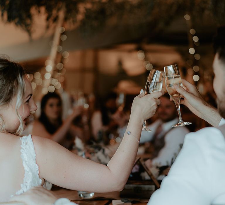 Bride & groom cheers champagne during tipi wedding reception at The Apple Orchard