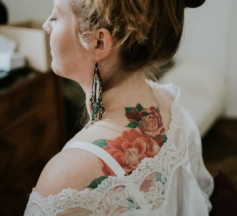 bride with tattoo in getting ready robe 