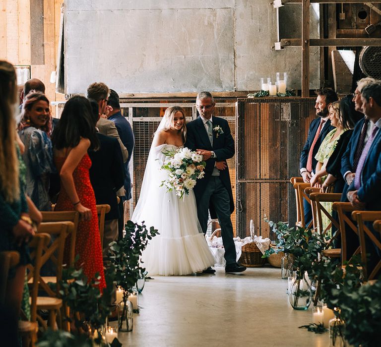 Festival barn wedding at Willow Grange Farm with bride in tulle wedding dress walking down the aisle with her father 