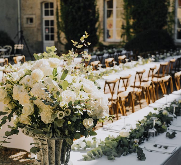 white wedding flowers and green foliage floral arrangement at outdoor wedding reception 