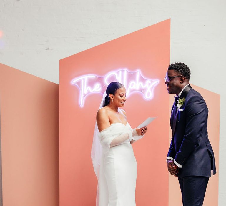 Barbie pink wedding decor for the altar with pink neon sign as the two couples exchange vows 