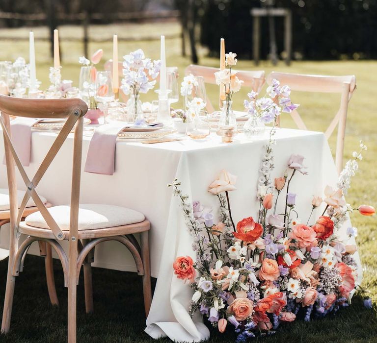 Wedding tablescape flower arrangement with peach garden roses, white peonies, lilac sweet peas, bluebells and wildflowers at Rackleys Barn